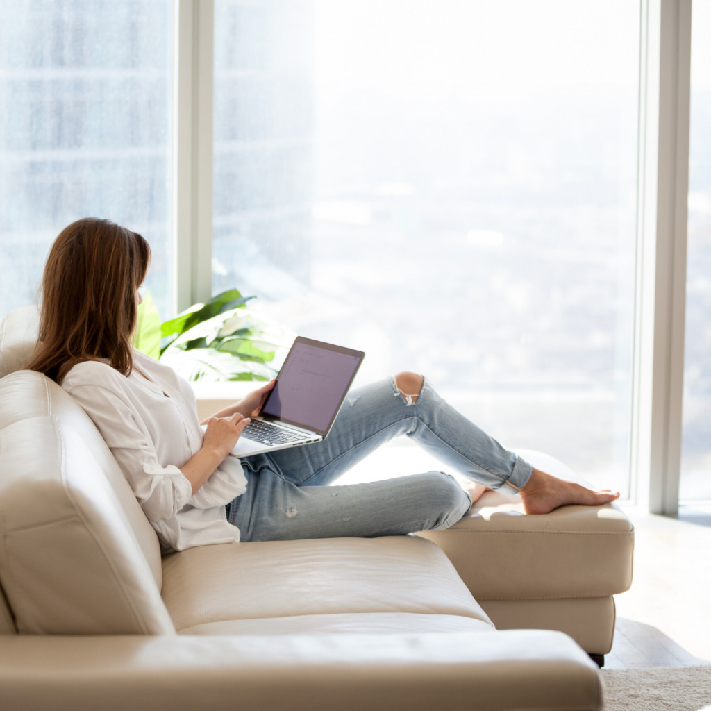 Relaxed,Woman,Using,Laptop,In,Luxury,Home,Living,Room,With
